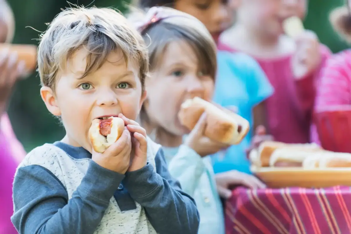 Lille dreng spiser en hotdog